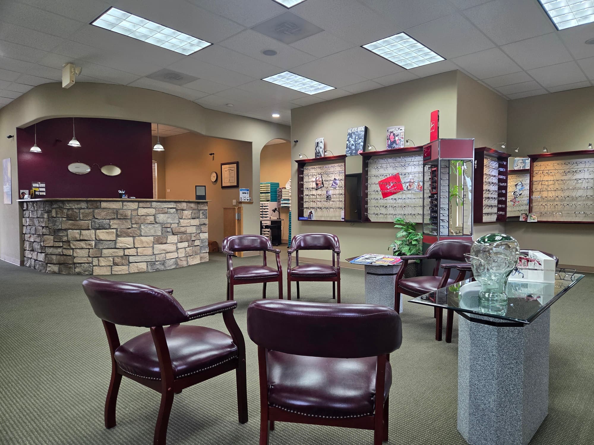 Eyewear showroom with frame walls and burgundy chairs